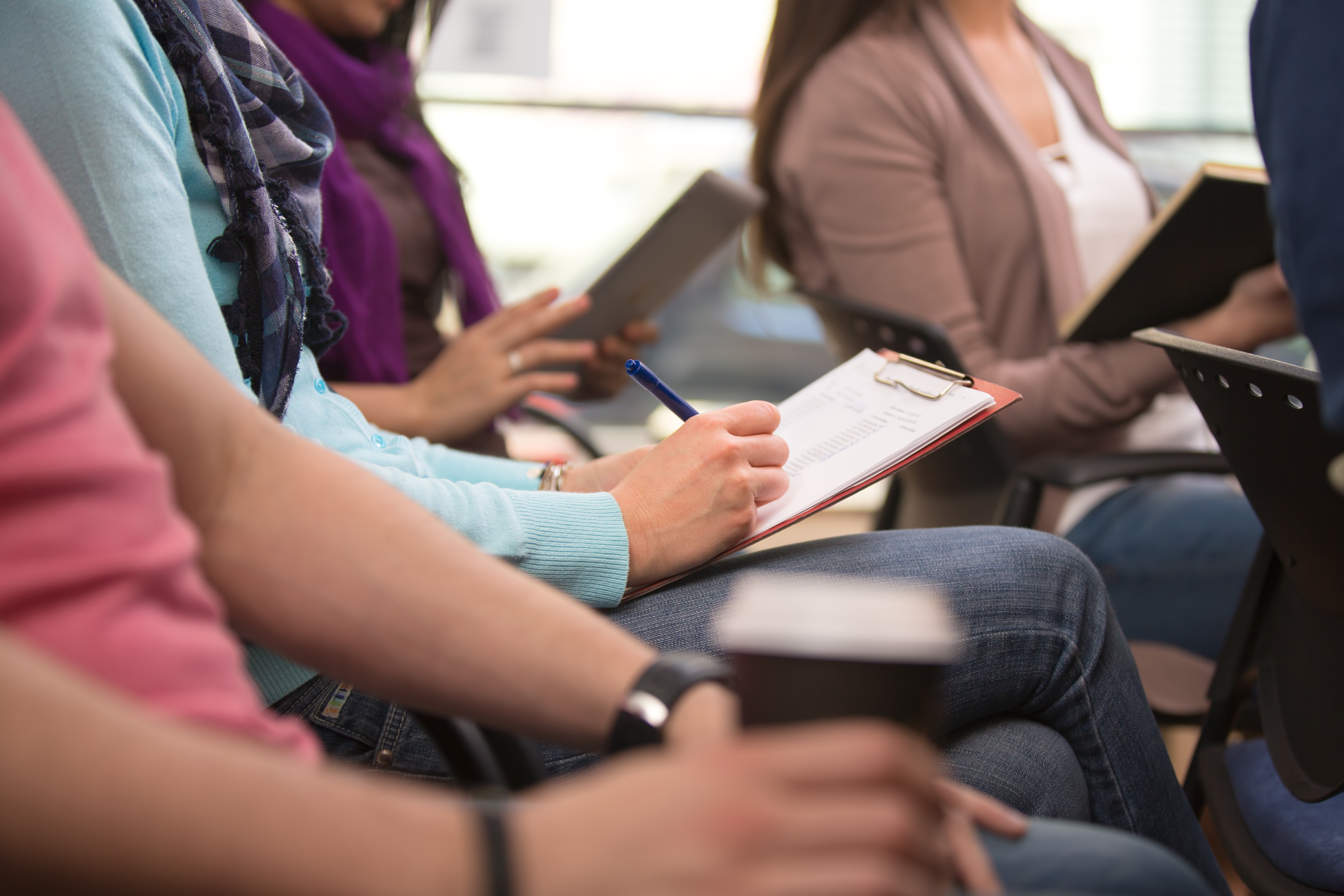 Close up view of student taking notes during lecture