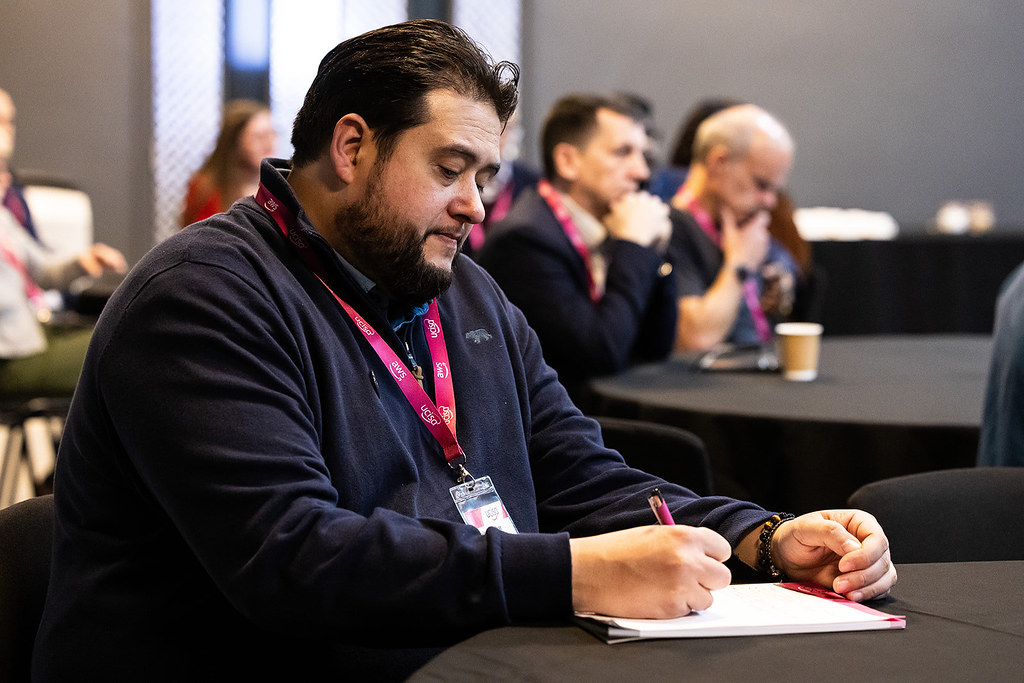 A man at the UCISA conference writing notes.